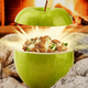 Apple full of stuffed meat and cheese in front of a fire